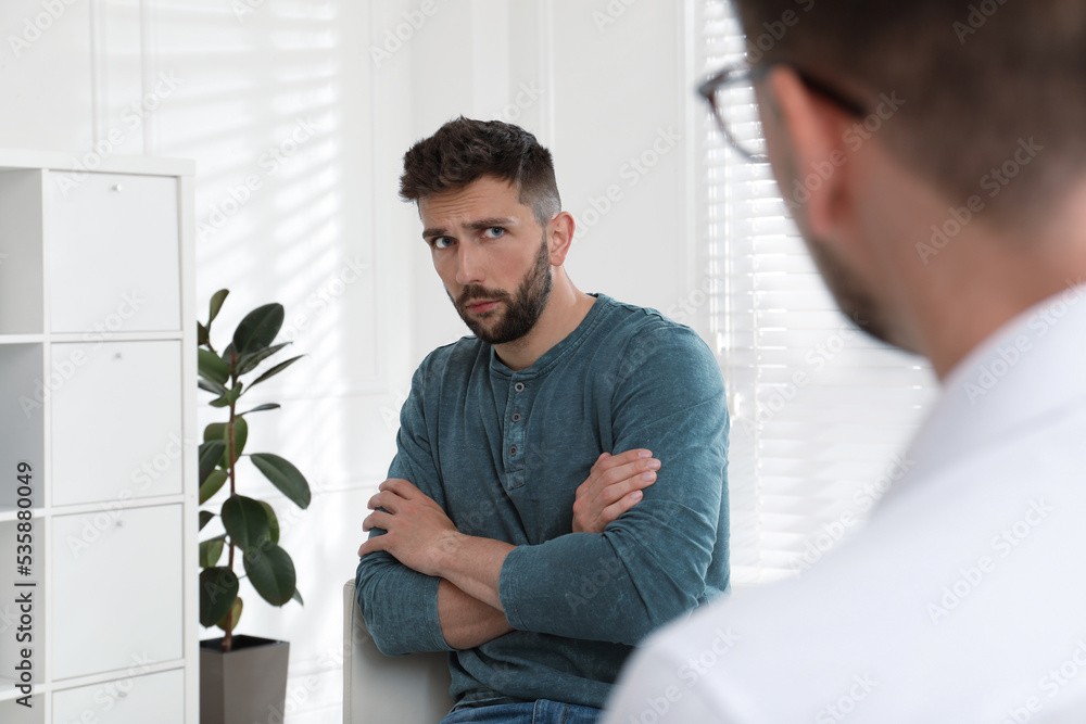 Psychotherapist working with drug addicted man indoors