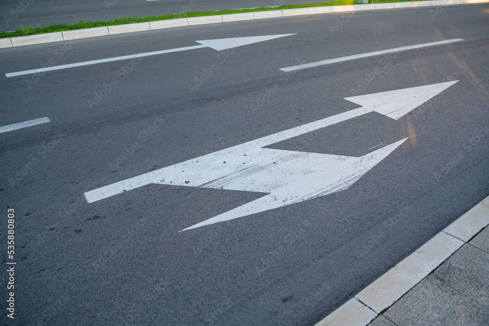 a close-up of a sign drawn on the road signifying a right turn or straight ahead. Tools for regulating traffic rules. Road signs. a close-up of a sign drawn on the road signifying a right turn or straight ahead. Tools for regulating traffic rules. Road signs.