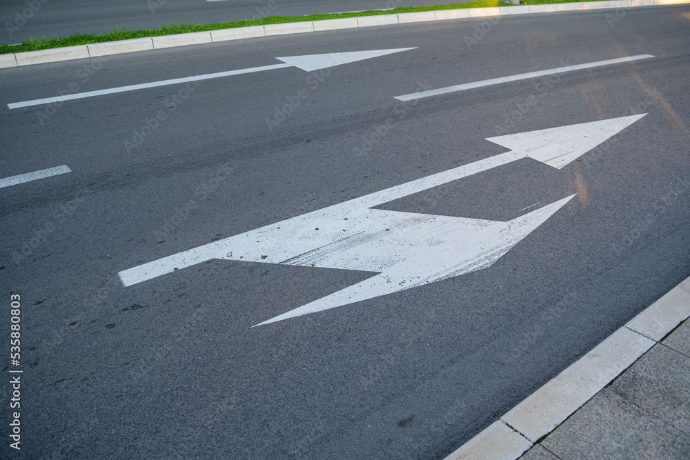 a close-up of a sign drawn on the road signifying a right turn or straight ahead. Tools for regulating traffic rules. Road signs.