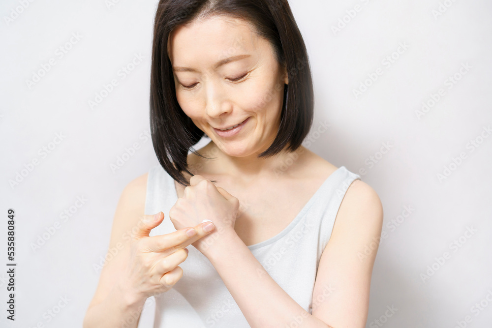 手の甲にクリームを塗る女性 手の甲にクリームを塗る女性