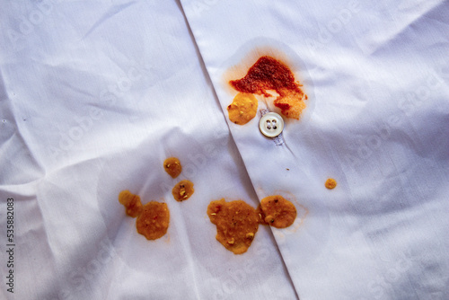 Food stains on shirt. Top view tomato sauce dirt on white shirt. photo