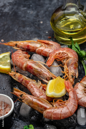 Seafood. Red Argentine shrimps with salt and lemon, Wild shrimps, ocean jumbo shrimps on a dark background. vertical image. top view. place for text