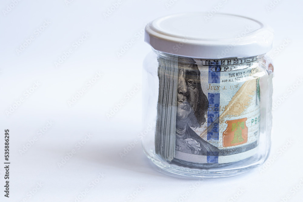 100 dollar banknotes in jar on white background 100 dollar banknotes in jar on white background