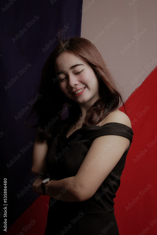 Naklejka premium Young Asian women wear dresses or dark clothes. Take pictures and express themselves inside the indoor studio.
