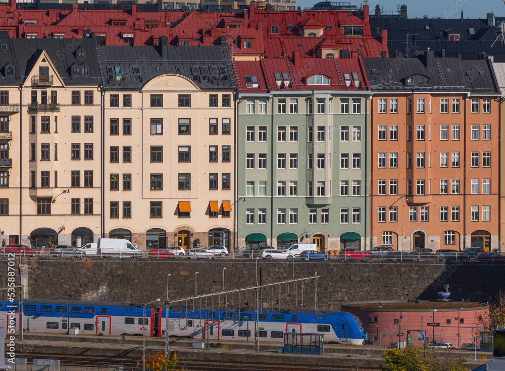 Commuting train and apartment buildings in the district Vasastan a sunny autumn day in Stockholm