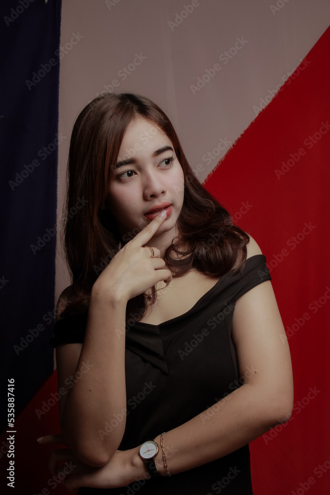 Young Asian women wear dresses or dark clothes. Take pictures and express themselves inside the indoor studio. Young Asian women wear dresses or dark clothes. Take pictures and express themselves inside the indoor studio.