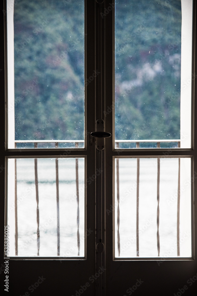 A window with Lake Lugano in the background in Switzerland during the summer. A window with Lake Lugano in the background in Switzerland during the summer.