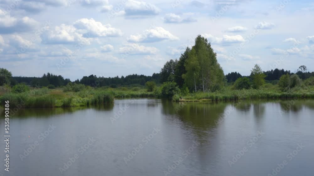 View of a quiet lake and green forests. Landscape countryside warm summer evenings. View of a quiet lake and green forests. Landscape countryside warm summer evenings.