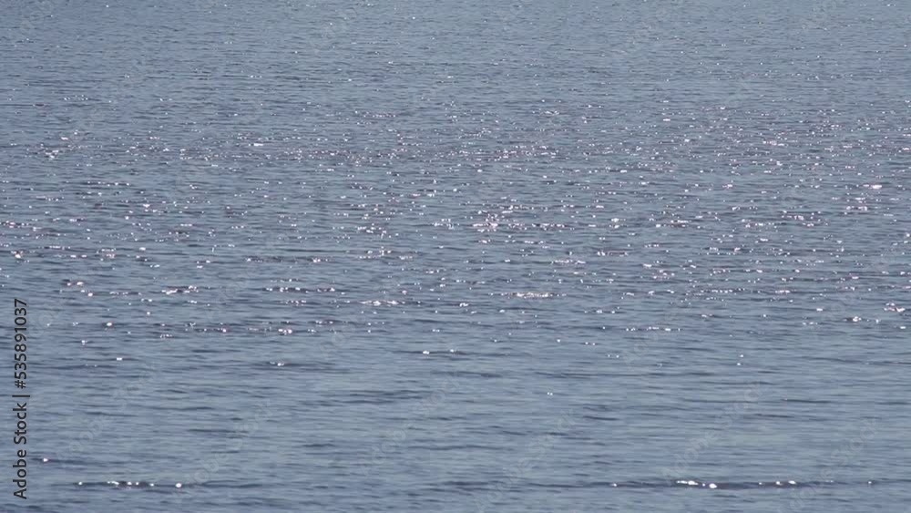 Sun glare on the water. Summer lake. Ripples, sun glare, circles on the waves of water. Sea ripple. Sun glare is blurred on blue turquoise water. Blurred water background, relax. Sun glare on the water. Summer lake. Ripples, sun glare, circles on the waves of water. Sea ripple. Sun glare is blurred on blue turquoise water. Blurred water background, relax.