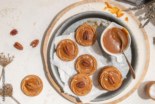 Homemade cookies with a generous dollop of Salted Caramel and pecan nut photo