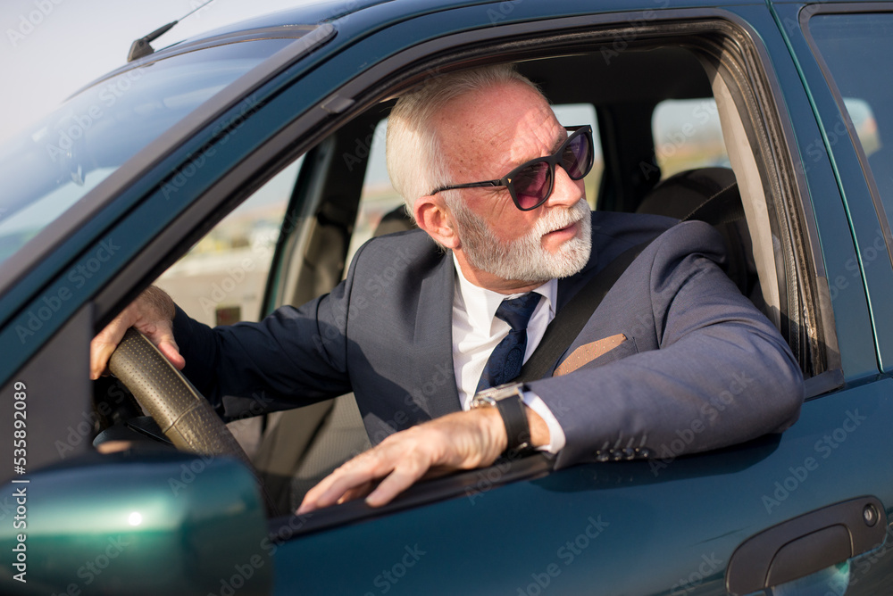 Senior businessman driving car and stuck in traffic jam