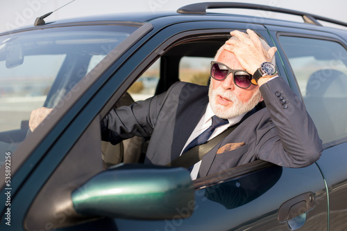 Fotografia, Obraz Senior businessman driving car and stuck in traffic jam