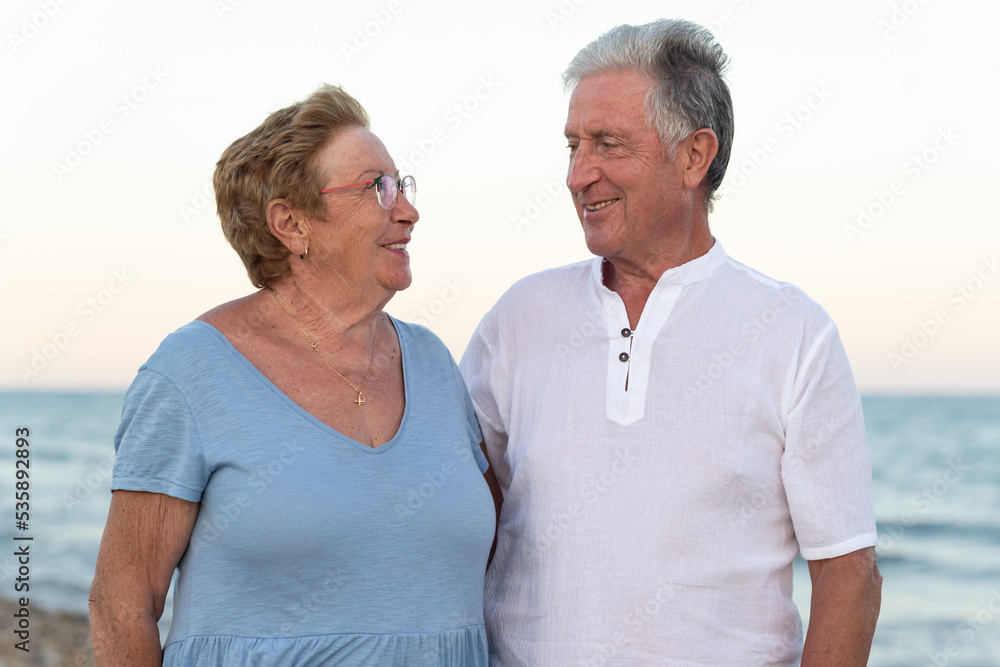Portrait of a smiling senior couple with the sea at the background at sunset. Portrait of a smiling senior couple with the sea at the background at sunset.