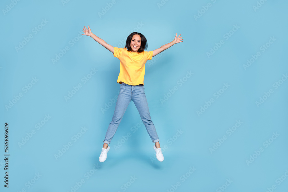 Full size photo of charming cheerful girl jumping make star figure isolated on blue color background