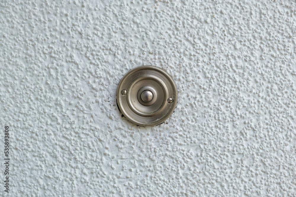 Close-up of a stainless steel doorbell button on a white wall Close-up of a stainless steel doorbell button on a white wall