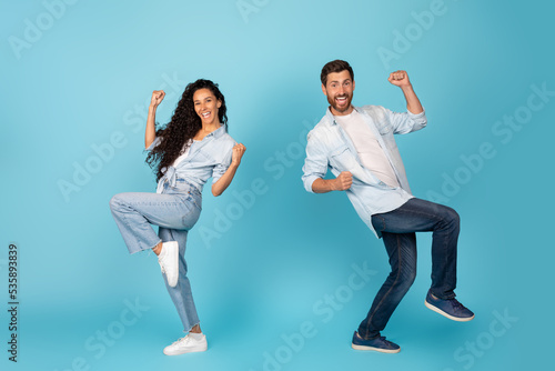 Satisfied excited young caucasian and arab people rejoice to success, dance and make victory gesture