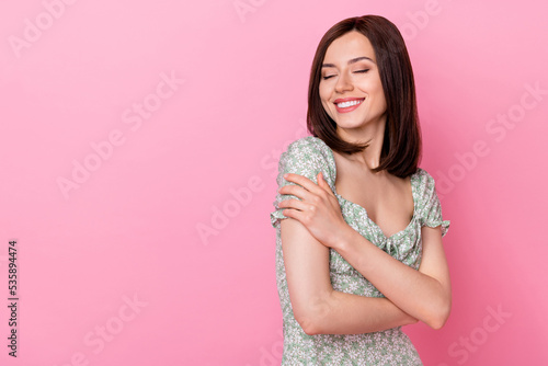 Photo of sweet pretty cute girlfriend lady wear stylish outfit hug herself eyes closed stand empty space isolated on pink color background