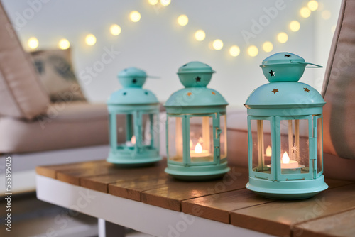 Obraz na płótnie Cozy decorative lanterns with candles on outdoor chill-out terrace table with wa