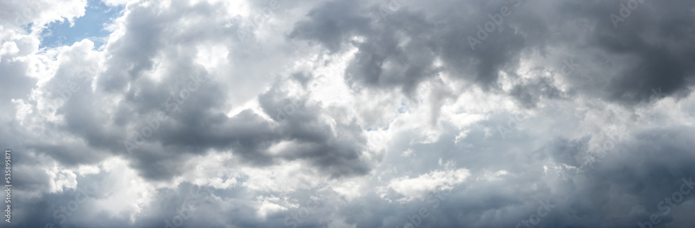 Gray storm clouds thickly covered the sky, sunlight penetrates through the clouds Gray storm clouds thickly covered the sky, sunlight penetrates through the clouds