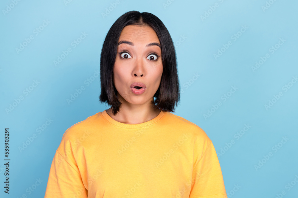 Portrait of positive gorgeous nice woman with bob hairdo dressed yellow t-shirt impressed staring isolated on blue color background Portrait of positive gorgeous nice woman with bob hairdo dressed yellow t-shirt impressed staring isolated on blue color background