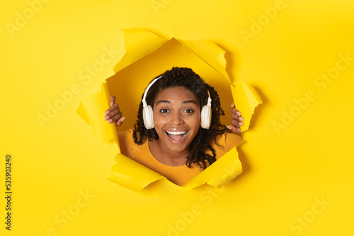 Black Lady Wearing Headphones Listening Music Posing In Torn Paper © Prostock-studio
