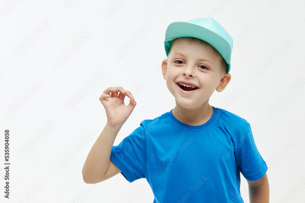 Stylish child boy laughing merrily with wide open mouth. Shows ok gesture with fingers on a white isolated background Stylish child boy laughing merrily with wide open mouth. Shows ok gesture with fingers on a white isolated background
