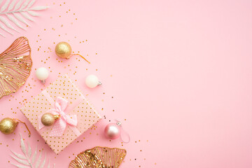 Present box at pink background with holiday decorations. White and golden christmas decorations flat lay with space for your text.