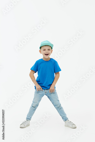 Stylish child boy laughing merrily with wide open mouth in a blue casual t-shirt and cap on a white isolated background