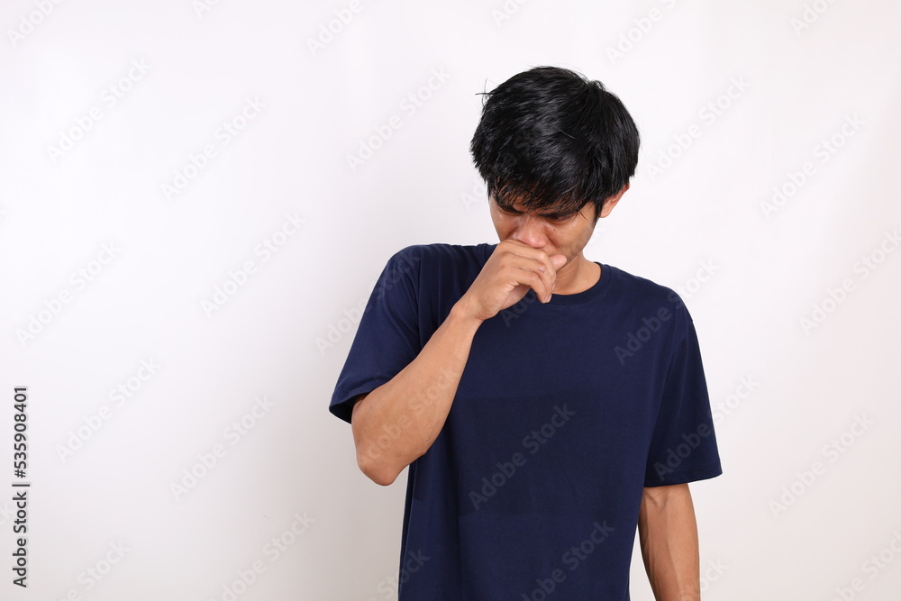 Asian young man standing while covering his nose. Bad smell concept. Isolated on white background Asian young man standing while covering his nose. Bad smell concept. Isolated on white background