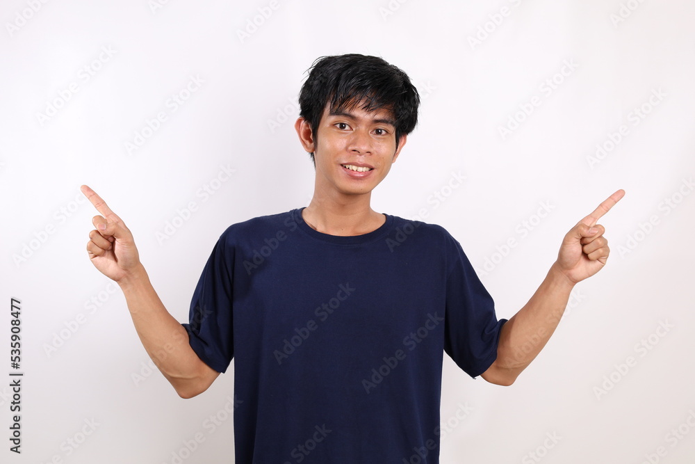 Happy asian young man standing while pointing both sides. Isolated on white background Happy asian young man standing while pointing both sides. Isolated on white background