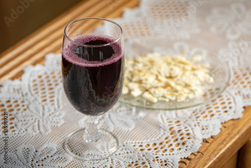 Grape juice in wine glass on table with unleavened matzah bread on lace for Christian church communion  photo