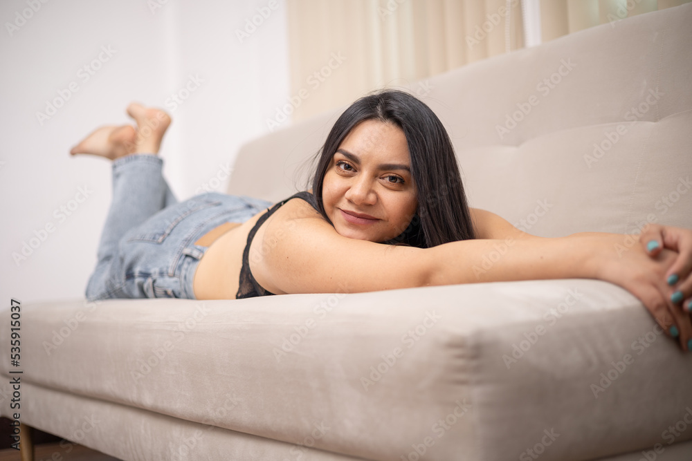 lying face down stretching and smiling beautiful young latin woman with long hair, lifestyle and natural beauty in studio lying face down stretching and smiling beautiful young latin woman with long hair, lifestyle and natural beauty in studio