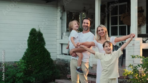 Happy caucasian family are standing near the house.