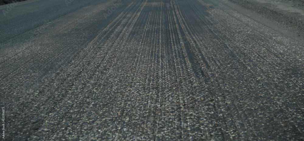 Naklejka premium Old asphalt. Budget repair of the road. Broken asphalt in the forest. banner