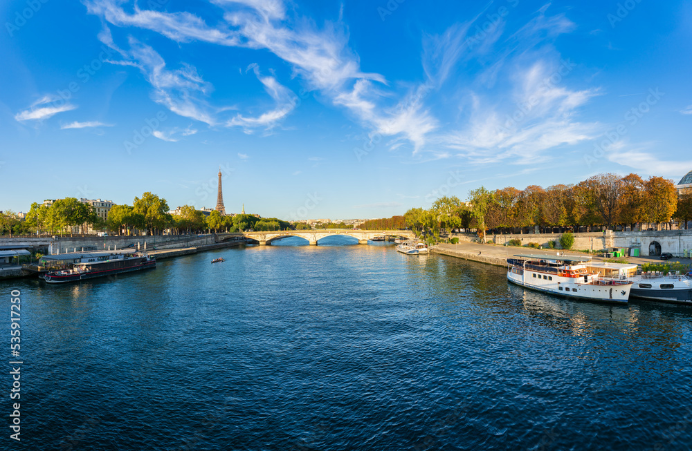 Sunny riverside panorama of Pont Alexandre III bridge with Eiffel Tower in the background in Paris. France