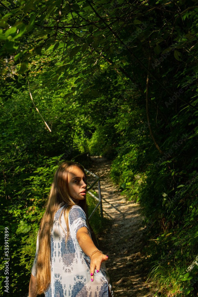 beautiful blonde in a swimsuit walks in the mountains