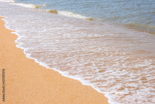 The coast of the Sea of Azov. Sea waves roll on the sandy shore. Seashell sandy beach.