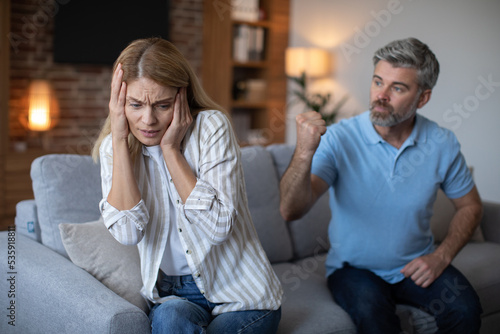 Vászonkép Aggressive angry mature caucasian husband threatens to frightened female with fi