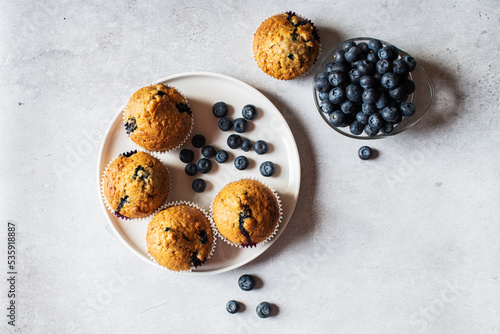 Blueberry muffins served in a plate on a marble background. Top view.