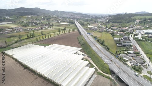 Aerial View Countryside or Rural Landscape. Tractor Working on Agriculture fields with Greenhouses. Vehicles Traveling on Hughway. 4k  photo