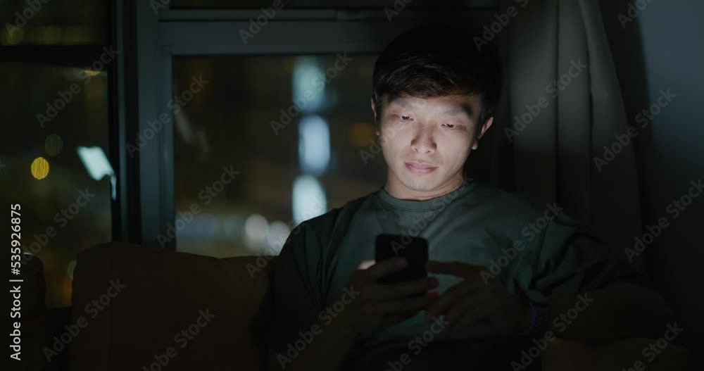 Asian man use mobile phone at home at night Asian man use mobile phone at home at night