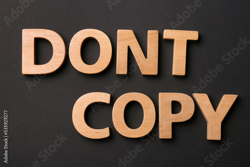 Words Don't Copy made of wooden letters on black background, flat lay. Plagiarism concept