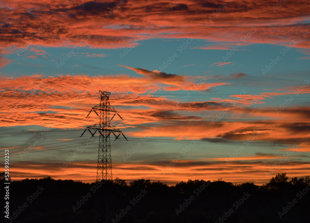 High Voltage Electricity Poles and wires. Power And Energy on the sunset