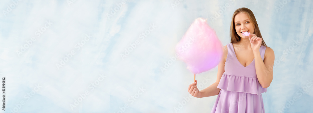 Beautiful woman with cotton candy on light blue background with space for text Beautiful woman with cotton candy on light blue background with space for text