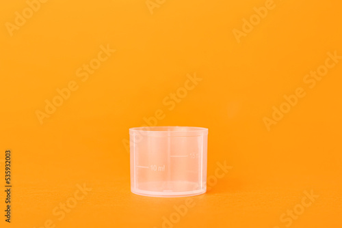 Cuadro en lienzo Empty measuring cup on orange background