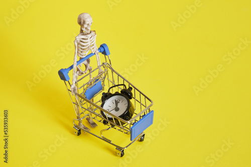 skeleton and shopping cart on yellow background