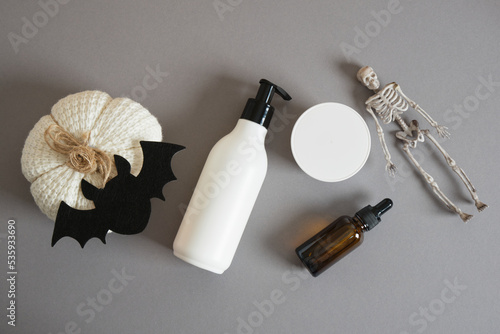 mockup bottle with dispenser, jar of cream, amber glass bottle with pipette, pumpkin, skeleton, bat