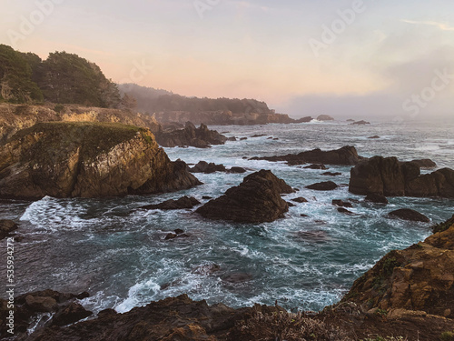 Waves crashing on rocks with sunset in Northern California 