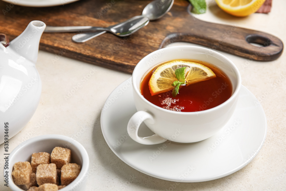 Cup of black tea with lemon and mint on white table, closeup Cup of black tea with lemon and mint on white table, closeup