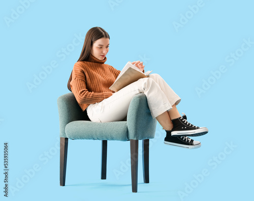 Young woman reading book in...